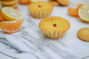 Lemon tartlets with fresh lemons and tangerines. photo