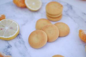 Lemon, orange and lemon slices on a white marble table. photo