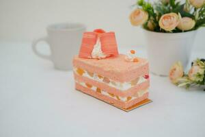 Piece of cake and cup of tea on white background, stock photo
