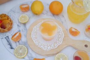 Fresh orange juice in glass and fresh citrus fruits on white background. photo