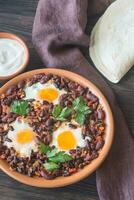 cuenco de chipotle frijol chile con horneado huevos foto