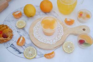 Fresh orange juice in glass and fresh citrus fruits on white background. photo