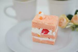 Piece of cake and cup of tea on white background, stock photo