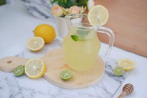 Lemonade with fresh lemon and mint leaves on a white background photo