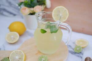 Lemonade with fresh lemon and mint leaves on a white background photo