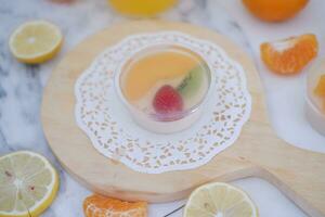 Fruit jelly with orange juice, lemon and kiwi on the table photo