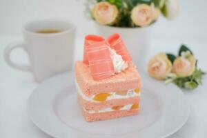 Piece of cake and cup of tea on white background, stock photo