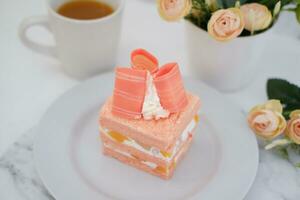 Piece of cake and cup of tea on white background, stock photo