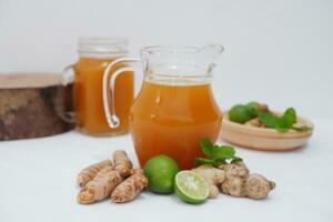 Ginger juice with fresh ginger and lemon on white background. Healthy drink. photo