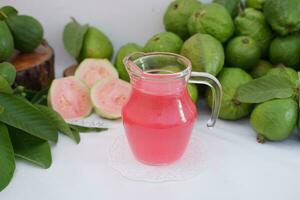Fresh guava juice in a glass and fresh guava fruit. photo