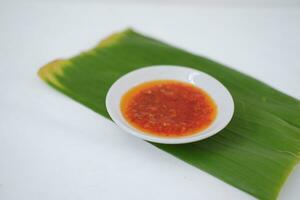 Thai style chili paste on banana leaf on a white background. photo