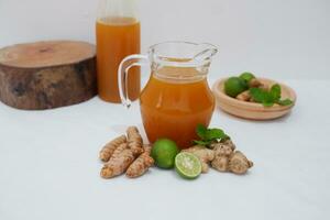 Ginger juice with fresh ginger and lemon on white background. Healthy drink. photo