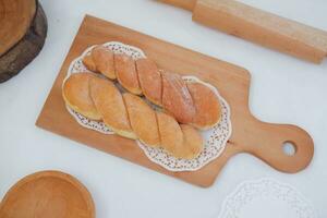 Bread donuts on the wooden table with wooden rolling pin. photo