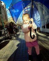 alegre pequeño dama con grande paraguas foto