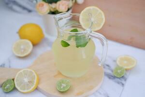 Lemonade with fresh lemon and mint leaves on a white background photo