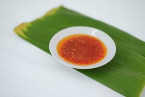 Thai style chili paste on banana leaf on a white background. photo