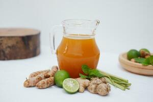 Ginger juice with fresh ginger and lemon on white background. Healthy drink. photo