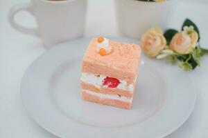 Piece of cake and cup of tea on white background, stock photo