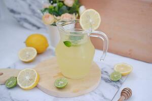 Lemonade with fresh lemon and mint leaves on a white background photo