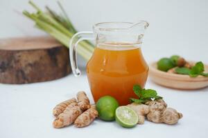 Ginger juice with fresh ginger and lemon on white background. Healthy drink. photo