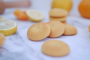 Lemon, orange and lemon slices on a white marble table. photo