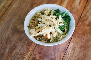 Fried noodle in white bowl on wooden table photo