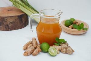 Ginger juice with fresh ginger and lemon on white background. Healthy drink. photo