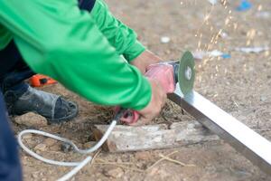 Industrial worker cutting steel with lots of sparks in steel grinding photo