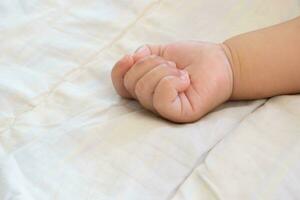 Baby hands sleeping on the bed photo