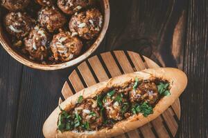 Hot dog bun stuffed with meatballs photo