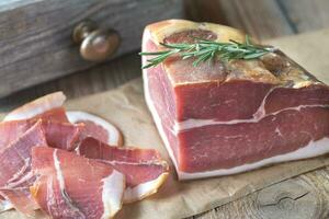 Prosciutto with fresh rosemary on the wooden board photo