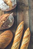 Different kinds of bread on the wooden background photo