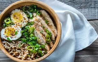 cuenco de pollo ramen sopa en el de madera mesa foto