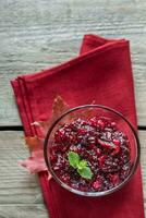 Bowl of cranberry sauce on the wooden board photo