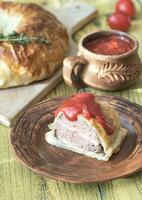 Portion of beef Wellington with tomato sauce photo