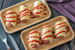 Sausage rolls on the wooden tray photo