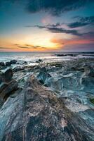 puesta de sol a el rocoso playa a vila estrella nueva Delaware gaia, Portugal. foto