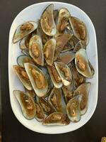 mejillones en un blanco plato foto