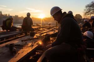 Engineers wearing safety helmets and working at sunset, photo