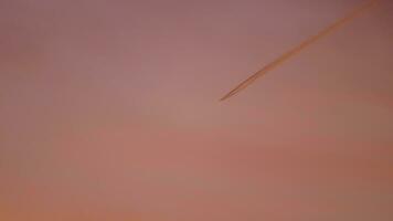4K Beautiful plane trail at sunset red light on the sky, aircraft layer pollution video