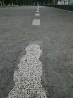 The middle line of the road is old and starting to fade, indicating that this road is very busy or worn out by time photo