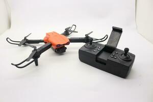 Orange drone with camera and remote control photo