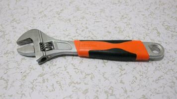 Adjustable Wrench with orange grip photo