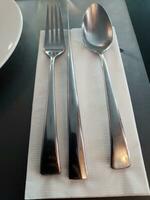 Spoons and forks on the dining table photo