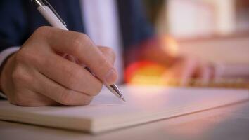 Businessman writing on notebook in office on table. Concept of finance planing and analyzes business and growth. working from home concept photo