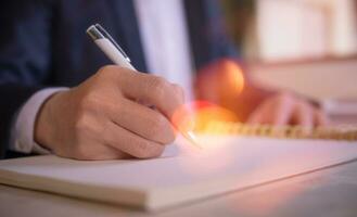 Businessman writing on notebook in office on table. Concept of finance planing and analyzes business and growth. working from home concept photo