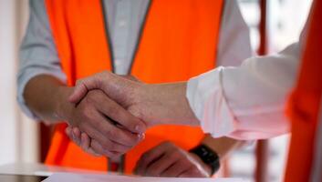 Engineers or foreman shaking hands at construction site, Construction worker in protective uniform shaking hands at construction site photo