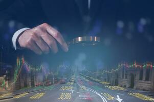 Businessman Holding Magnifying Glass Examining Trading Graph Stock Data for Market Analysis and Financial Strategy with blurred cityscape background photo