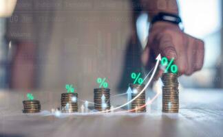 investment return on asset concept, interest rate increase percent, finance interest back rate increase , saving, deposit, businessman pointing at stacking of coins with percent symbol photo