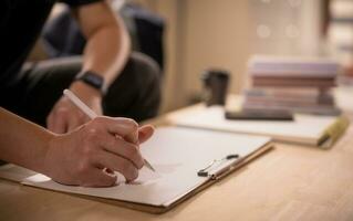 Businessman writing on notebook in office  on table. Concept of finance planing and analyzes business and growth. working from home concept. photo